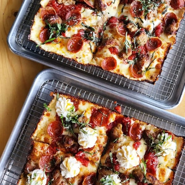 Two rectangular Sodough Square pizzas with pepperoni, sausage, basil, and dollops of ricotta.