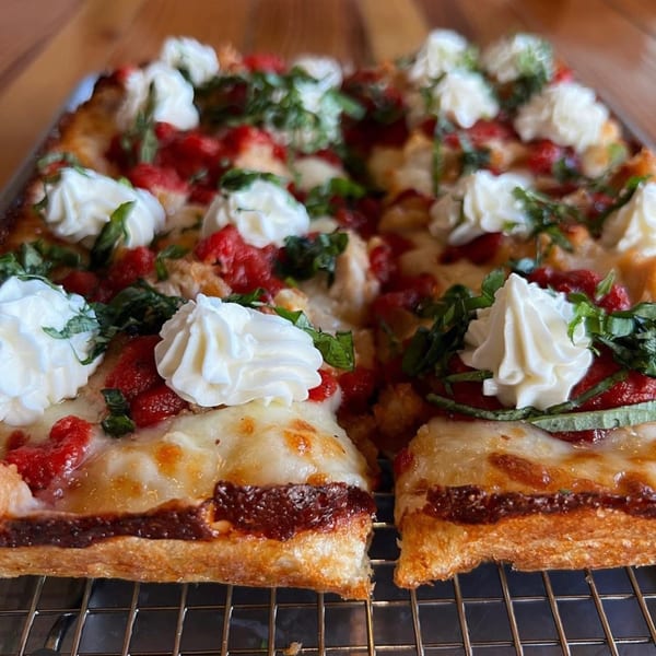Sodough Square's square pizza with red sauce, melted cheese, basil, and dollops of ricotta.