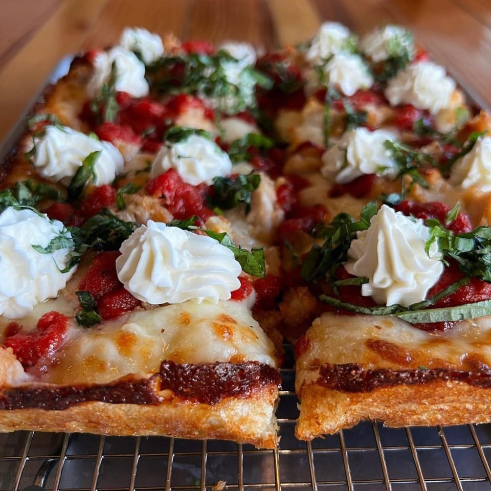 Sodough Square's square pizza with red sauce, melted cheese, basil, and dollops of ricotta.