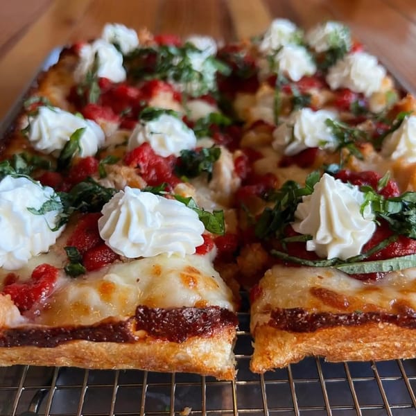 Sodough Square's square pizza with red sauce, melted cheese, dollops of ricotta, and fresh basil.